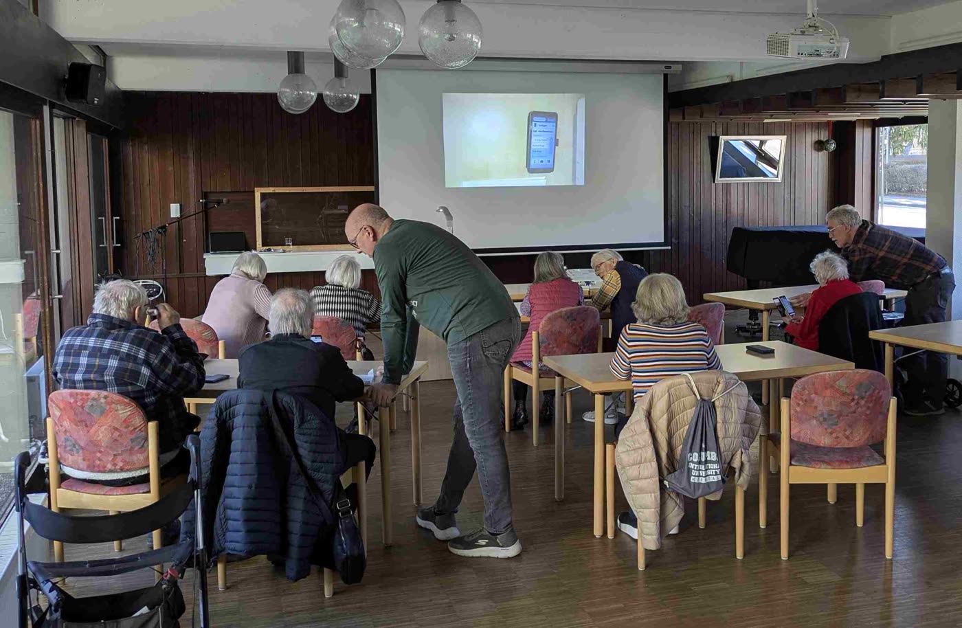 Mentoren helfen beim offenen PC-Treff an den Tischen weiter