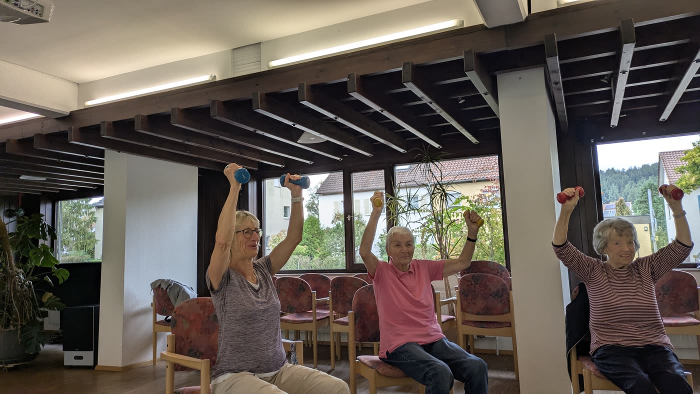 Teilnehmerinnen strecken die Arme nach oben