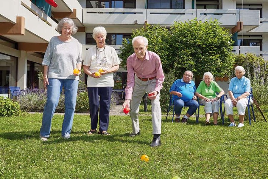 Bewohnerinnen und Bewohner spielen Boccia im Garten des Paul-Gerhardt-Hauses