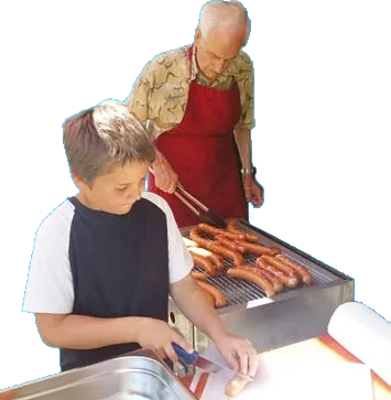 Ein Bewohner und ein Kind grillen gemeinsam beim Sommerfest