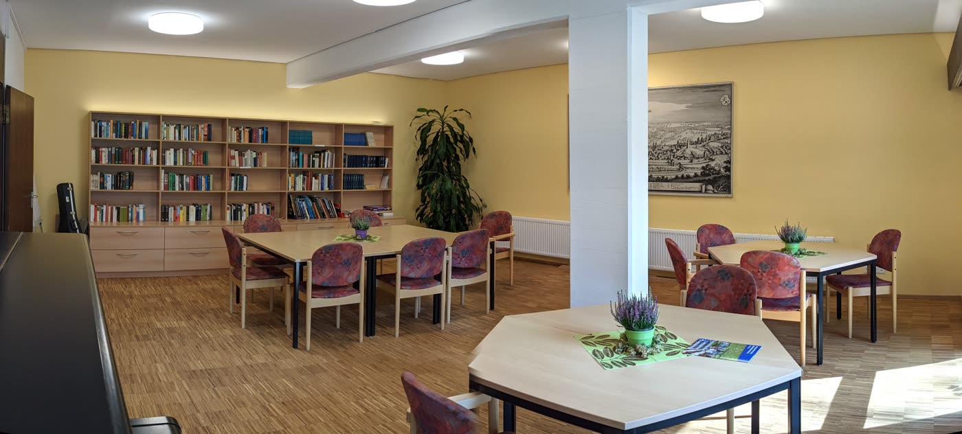 Gemeinschaftsraum mit Bibliothek und großem Tisch